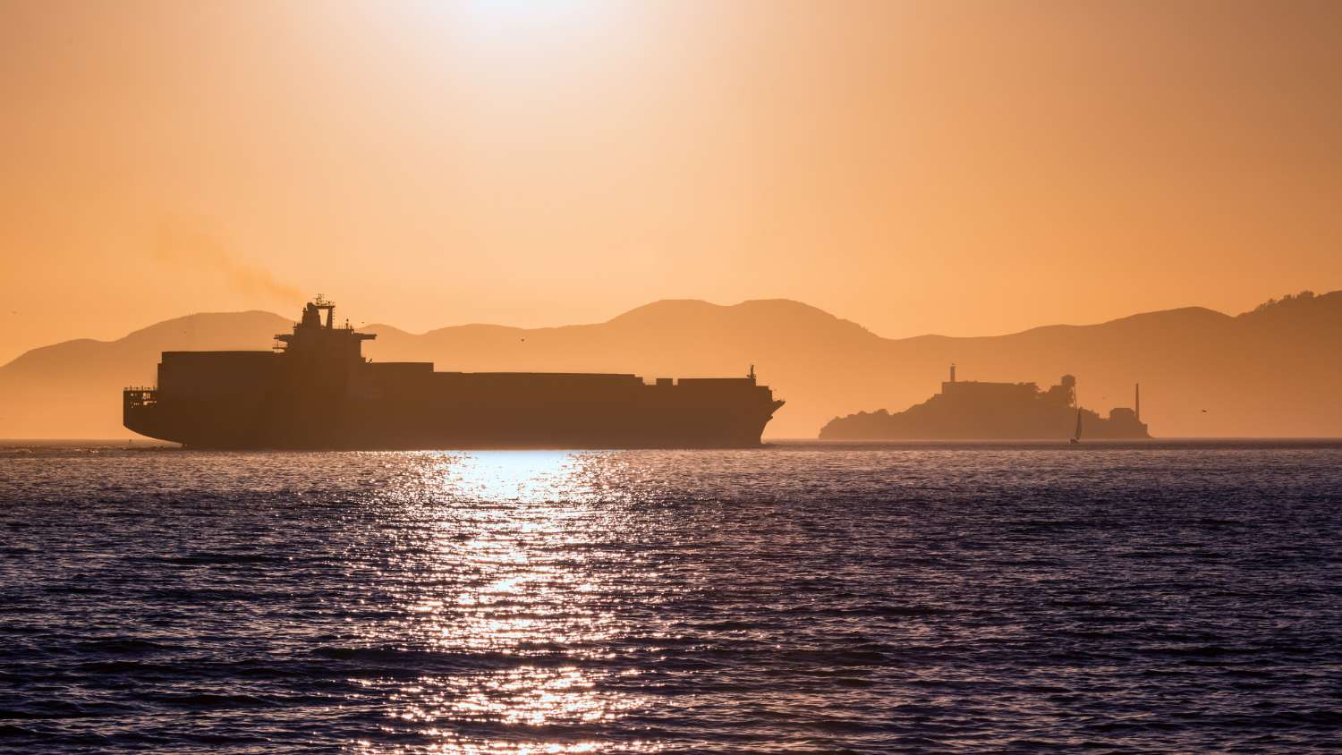 A picture of a tanker ship sailing at sunrise